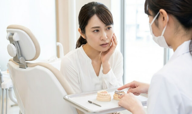 セラミック治療のデメリットを確認する女性
