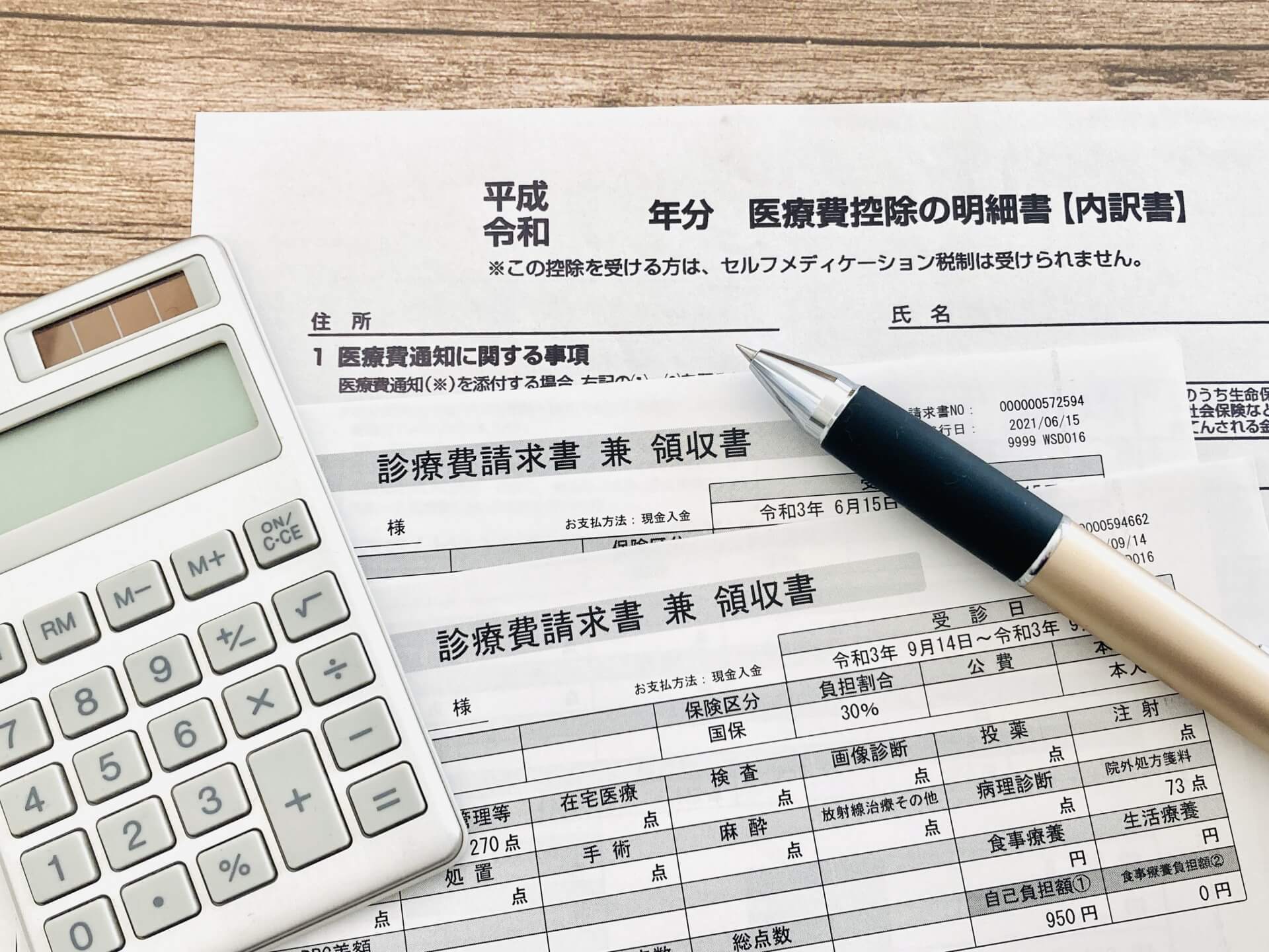医療費控除の申請手続きをイメージさせる明細書と領収書、筆記用具の組み合わせの様子