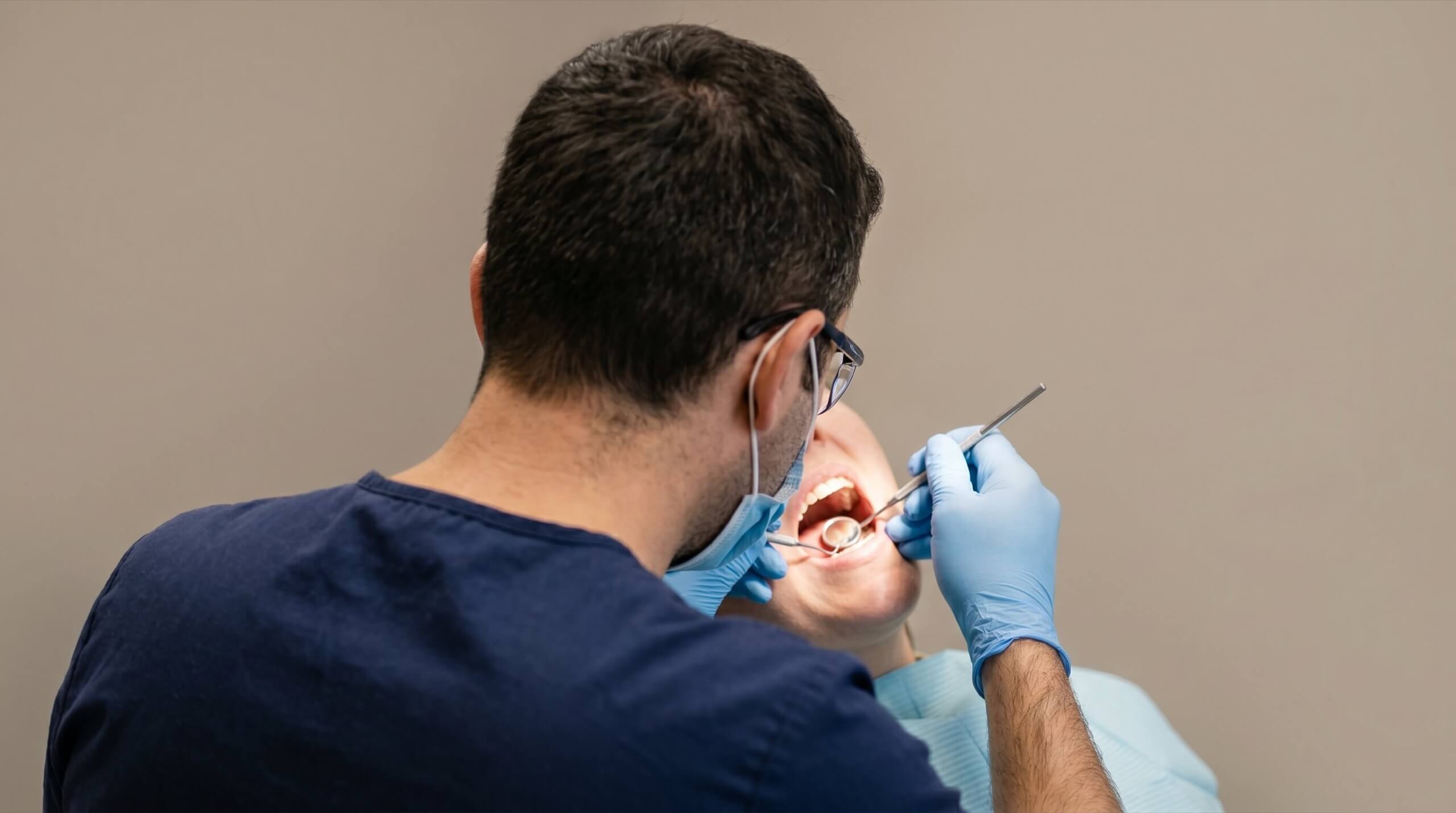 歯科医師が口腔内を診査する様子