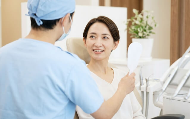 優しい雰囲気の歯科医院で、前向きに定期検診を受ける日本人女性
