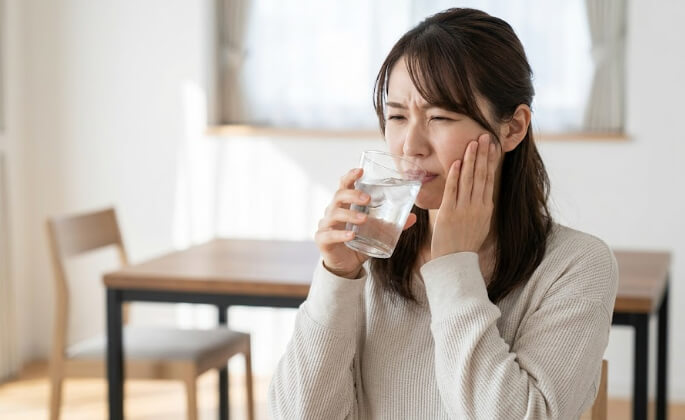 コップの冷たい水を飲んで歯がしみる、20代女性。